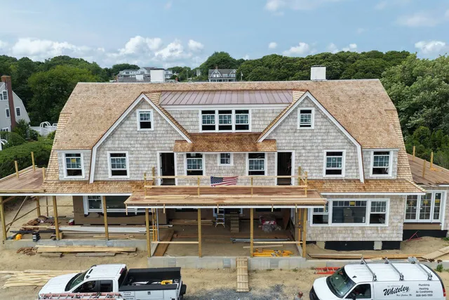 Sweeping gambrel roof covered in fresh red cedar shingles