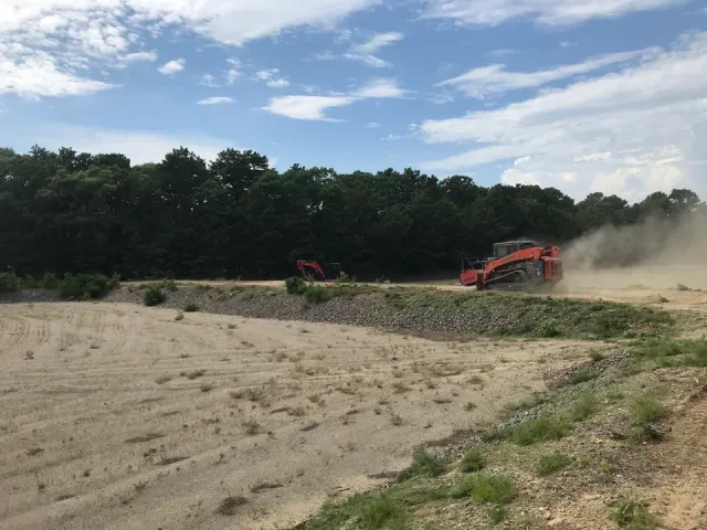 Skid Steer Driving Down Sandy Trail