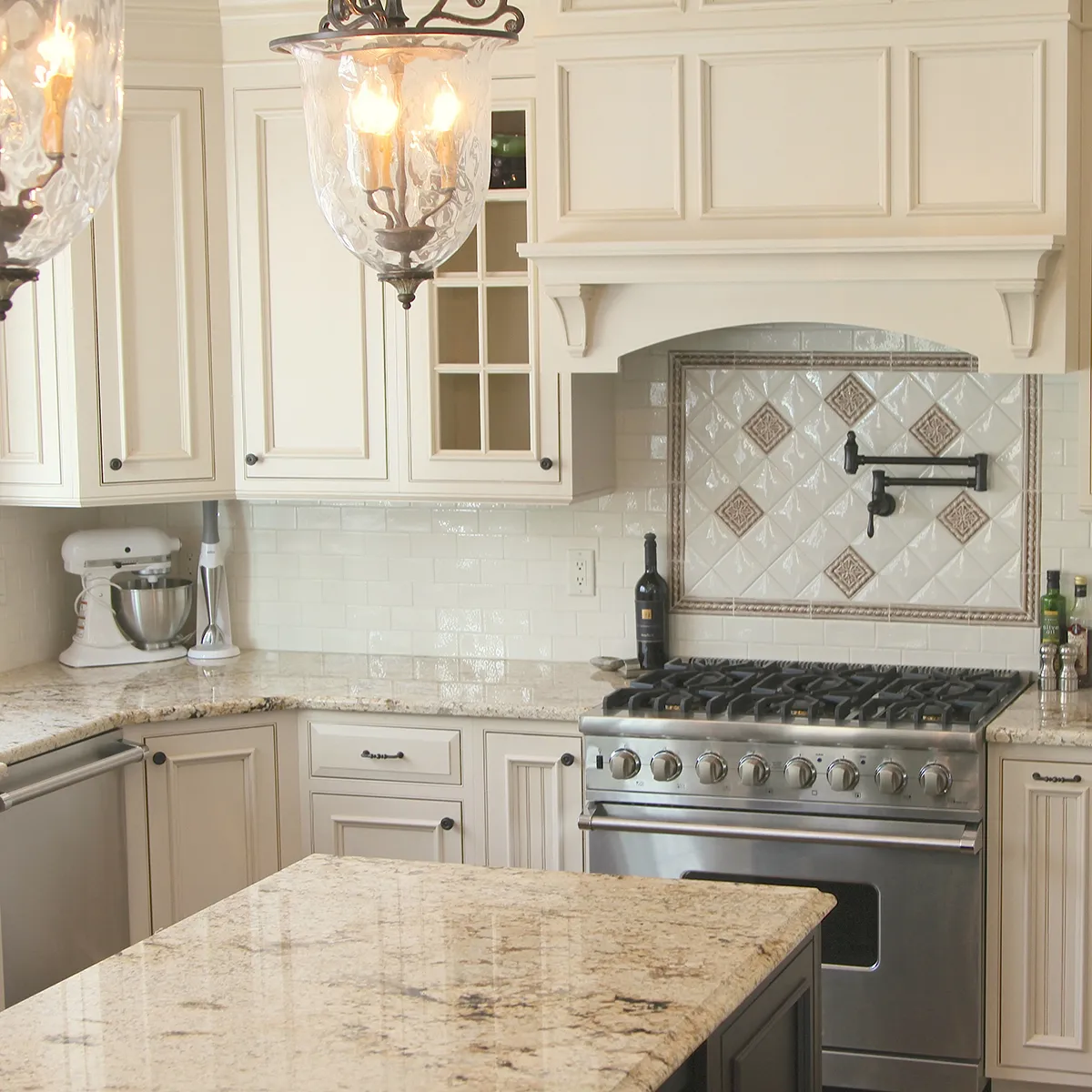 Elegant kitchen with cream cabinets, granite countertops, and a stainless steel stove.