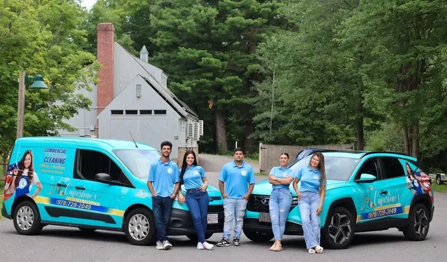 The Cupertino's Cleaning Services team standing in front of two branded vehicles