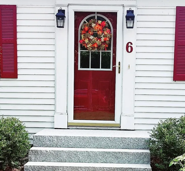 A red door with wreath on the front of it.