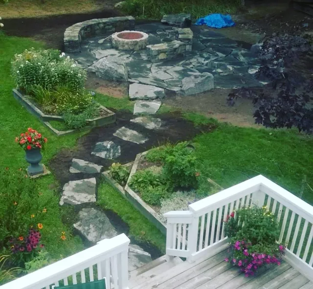 landscaped garden with blue stone patio, walk way and fire pit