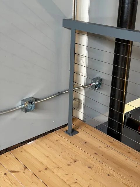 Close-Up of Electrical Wiring and Metal Railing on a Wooden Floor in an Industrial-Style Interior
