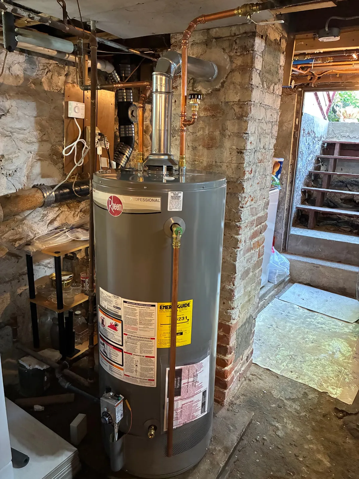 New Rheem gas water heater installed with copper piping in a Lowell, MA basement by Top Shelf Plumbing & Heating