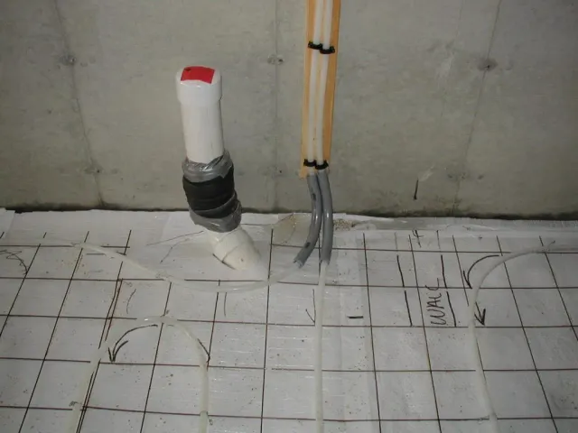 A white pipe with a red cap is sitting on a white tile floor