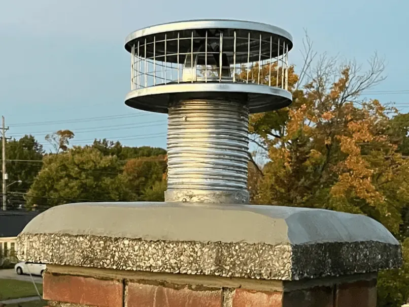 Stainless steel chimney liner being installed in flue