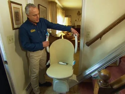 Rick Castino, a leader of the Operation Accessibility construction company, installs a stairlift.