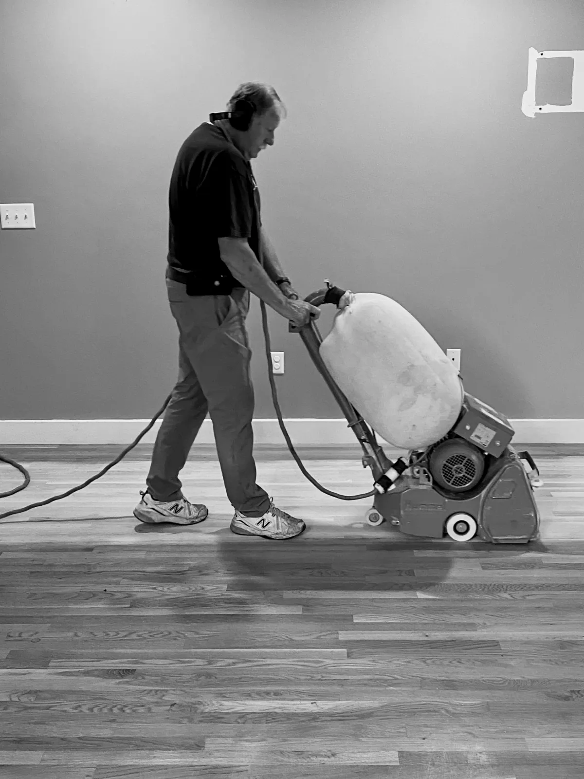 Sanding a floor with a drum sander