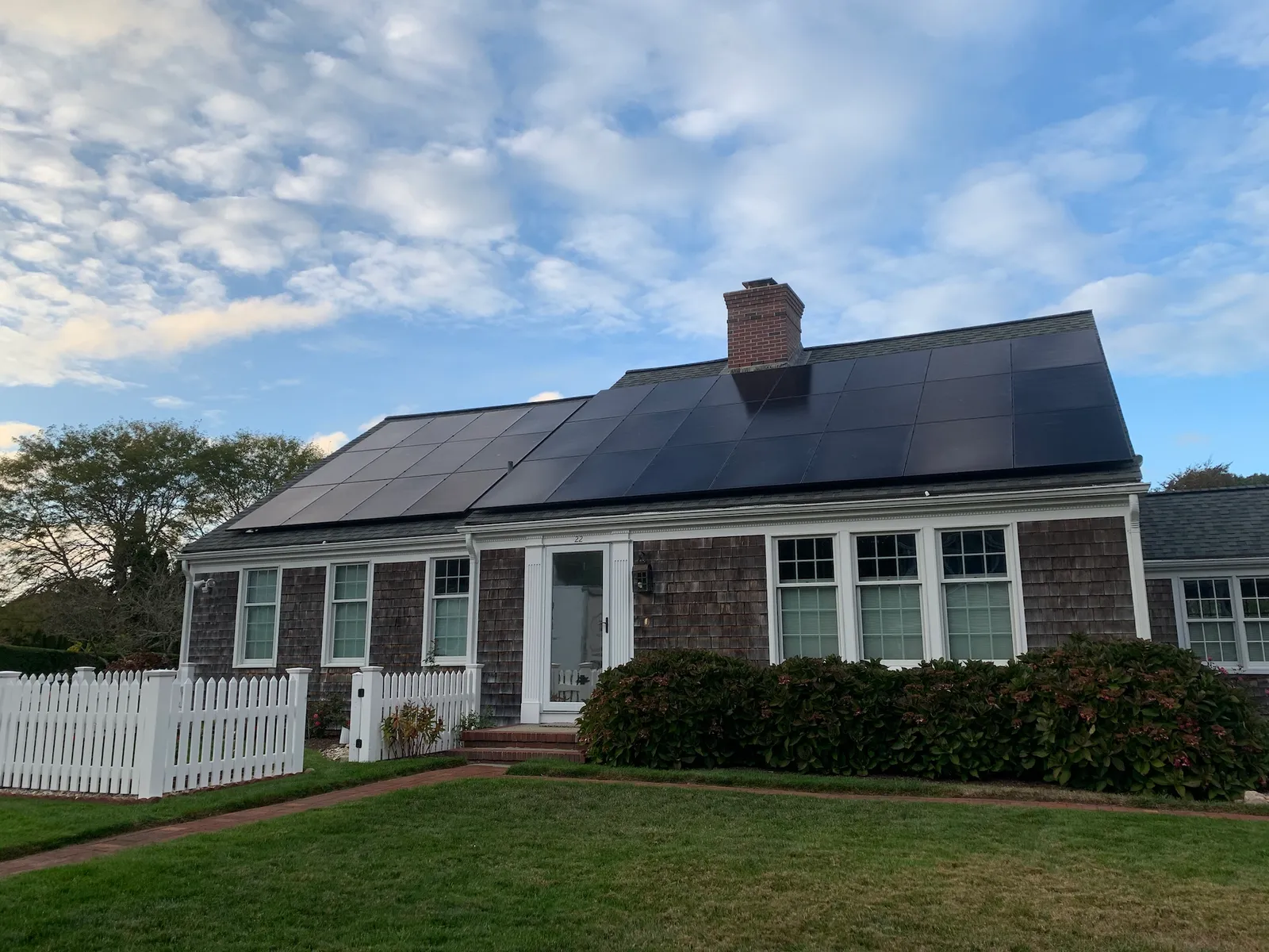 Cape Cod style home with solar panels covering the roof
