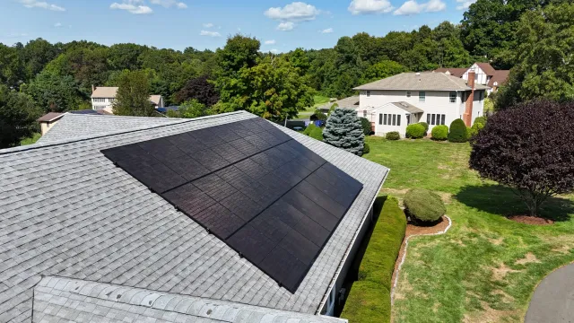 Residential rooftop with solar panels in a suburban neighborhood.