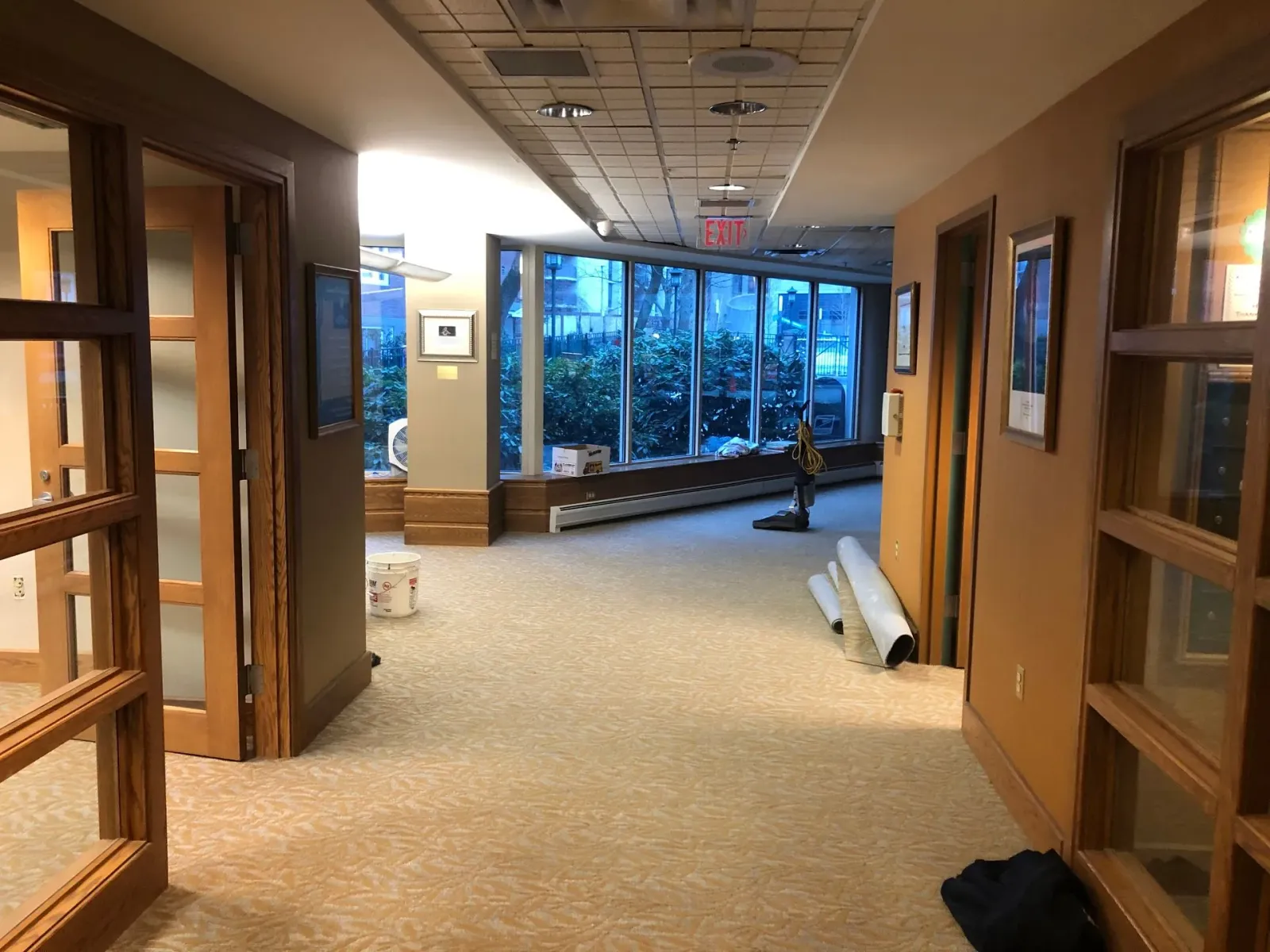 An empty hallway with a lot of windows and doors