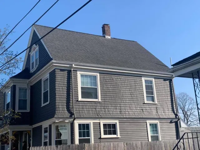 A large house with a gray roof and white windows