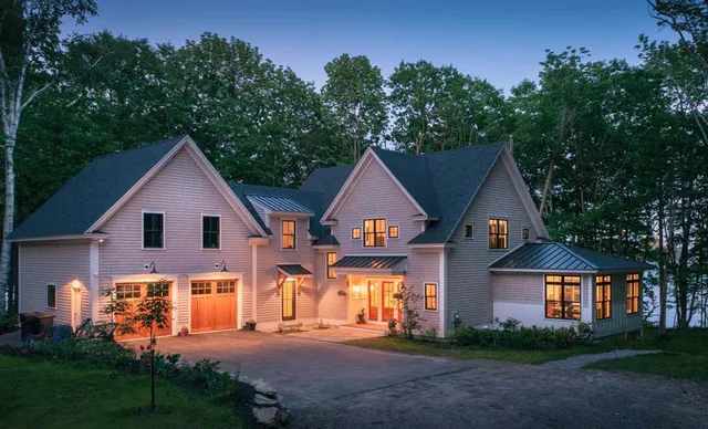 A large white house with two garage doors.
