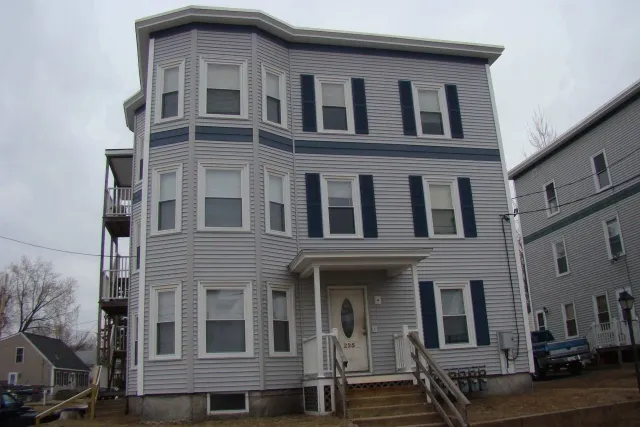 A large white building with black shutters on the windows