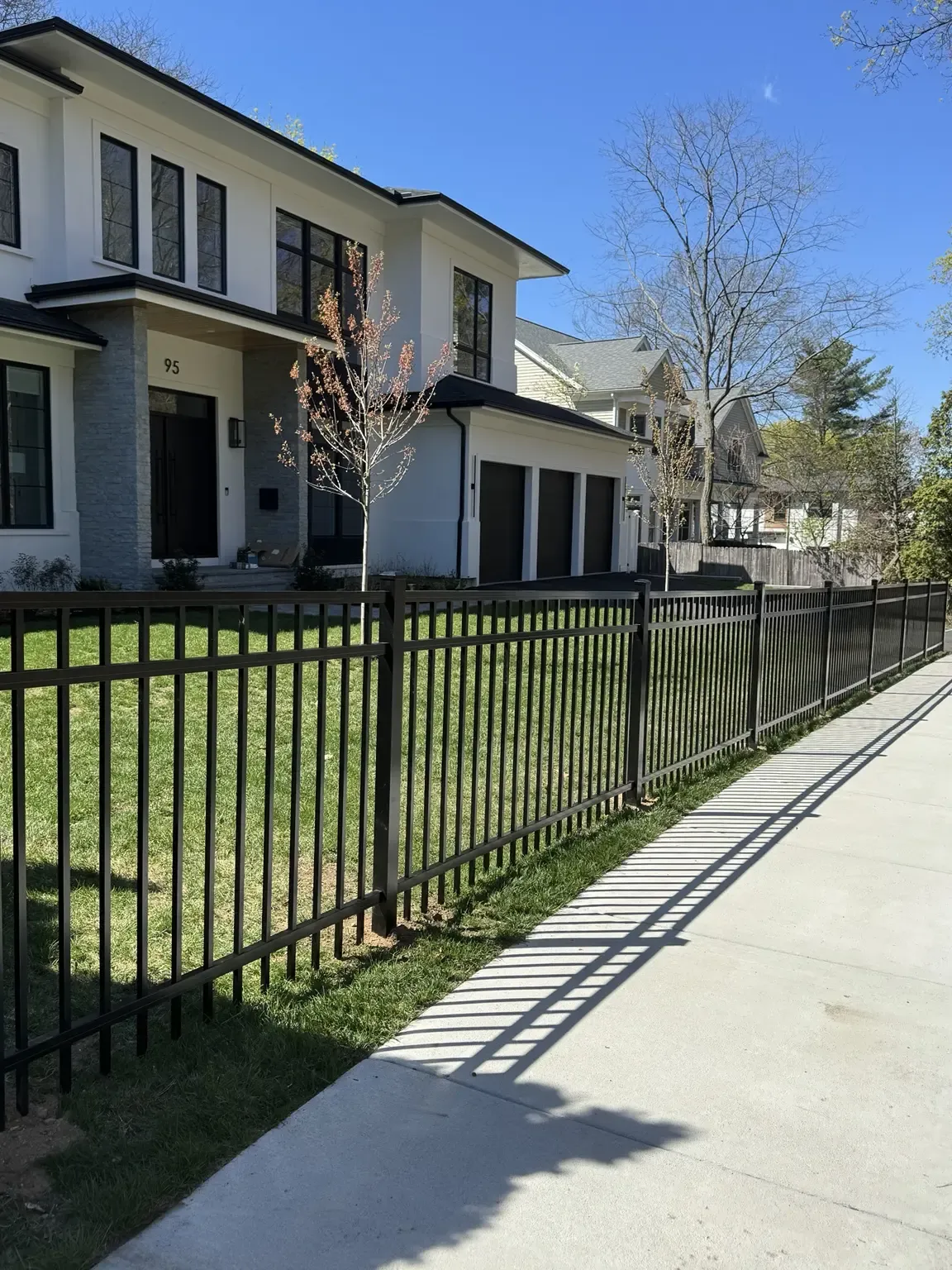 Black aluminum fence installed along the front of a home