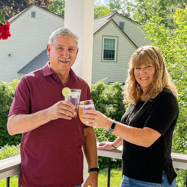 Happy homeowners toasting with a cocktail in their new home remodel