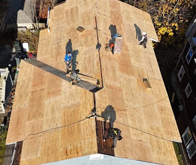 Roofers working on a home's plywood roof deck