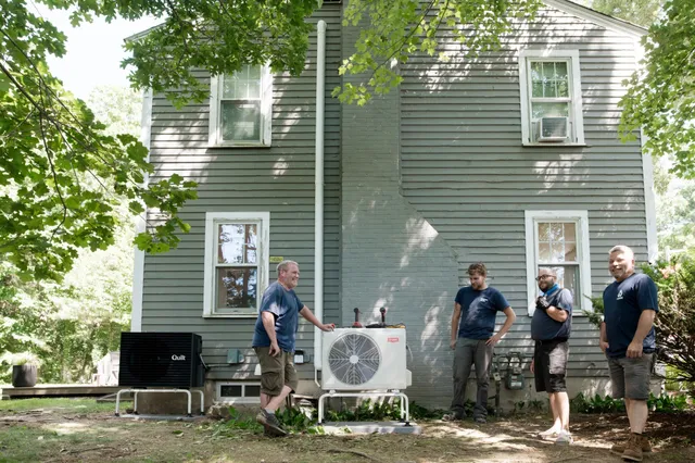 Forge HVAC technician hanging up a mini-split for a heat pump installation