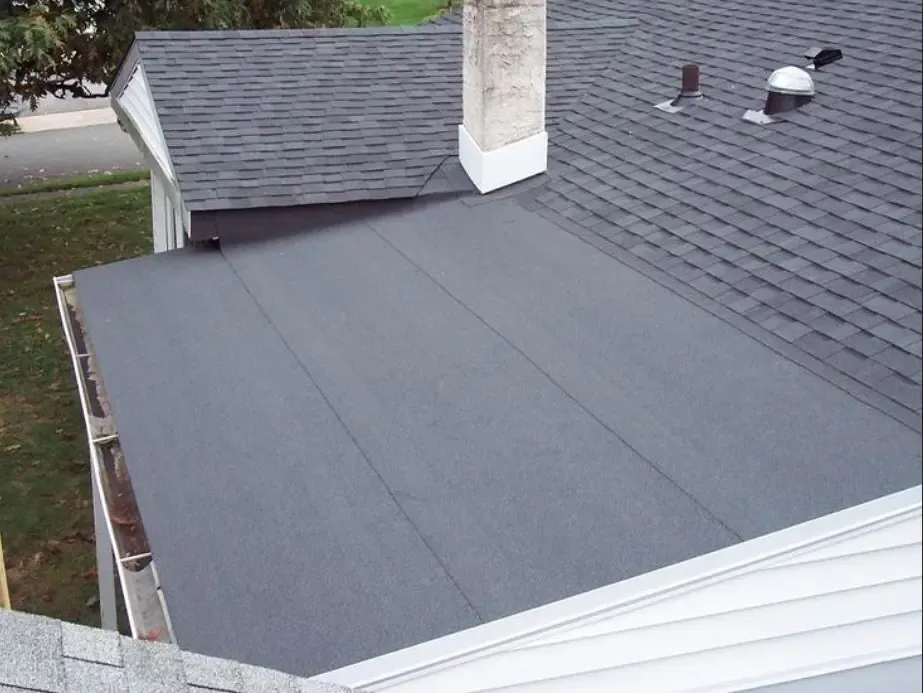 Roofing contractor stripping old shingles on a Greater Boston home