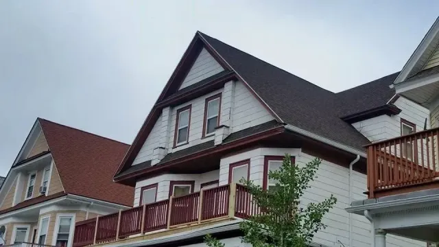 A white house with a brown roof and a balcony