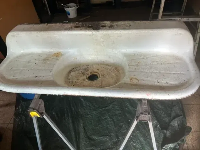 Rusted and stained vintage double drainboard sink before refinishing