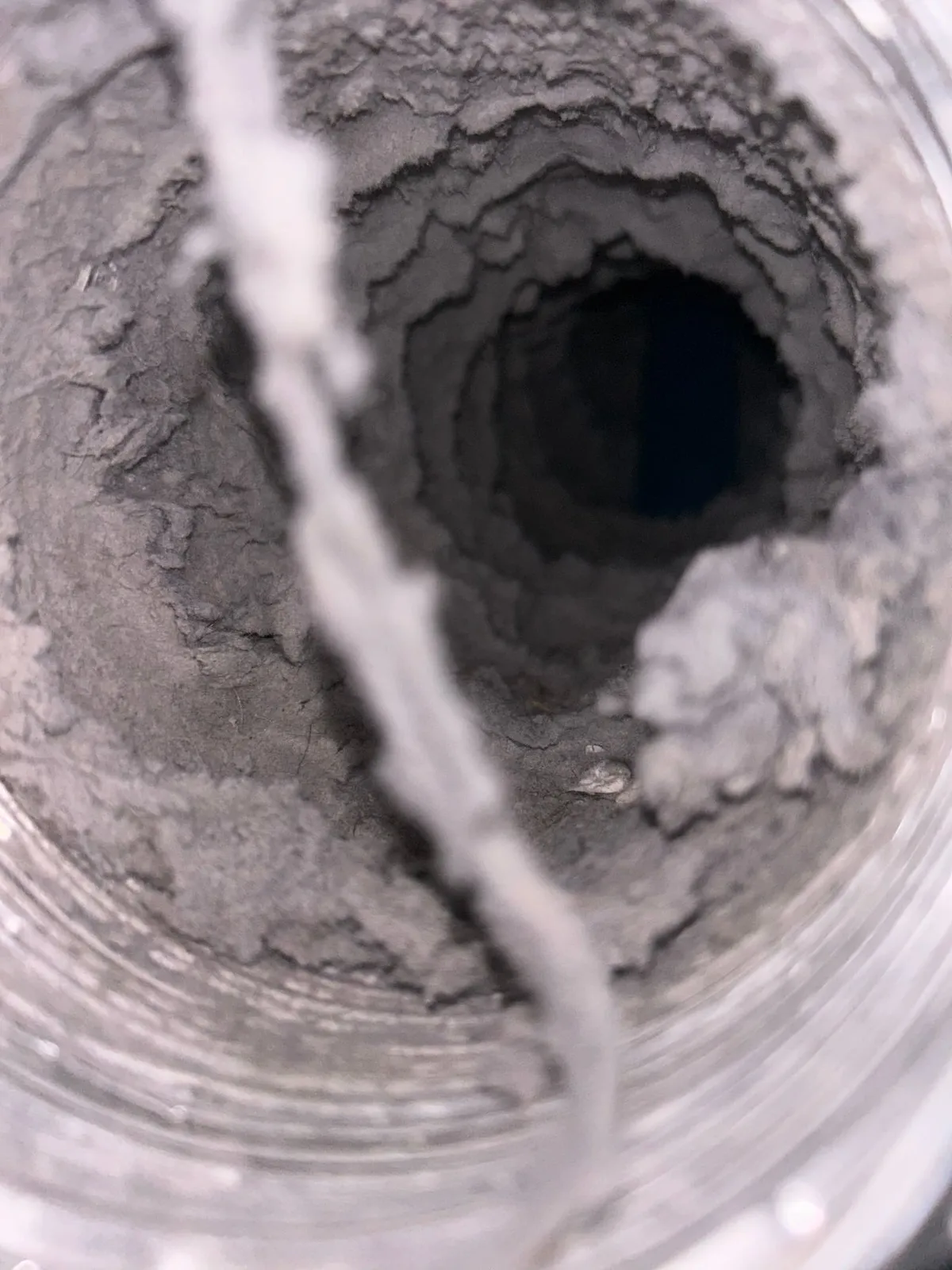 Thick lint lining the entire inner wall of a flexible dryer duct run.