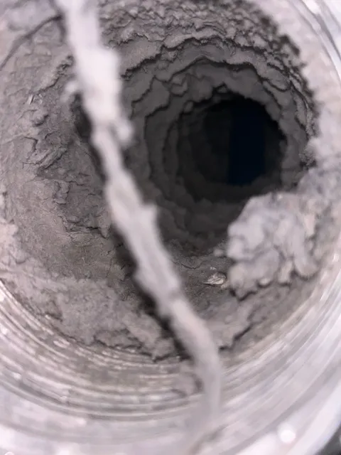 Thick lint lining the entire inner wall of a flexible dryer duct run.