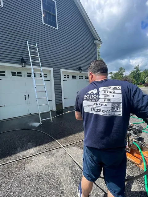 Worker Pressure Washing House