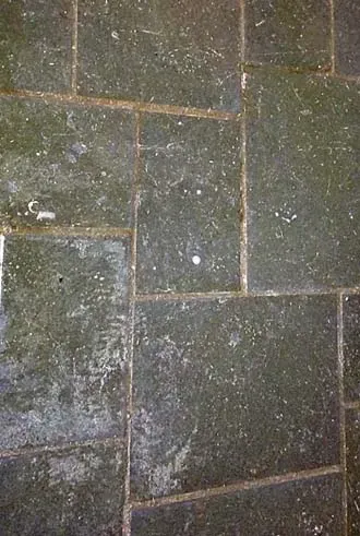Accessible shower with built-in bench, grab bar, multiple shower heads, and tiled walls/floor.