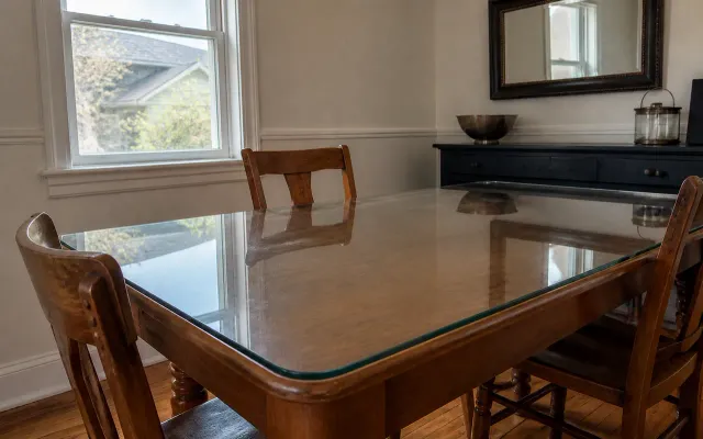 Custom glass tabletop installed over a traditional wooden dining table
