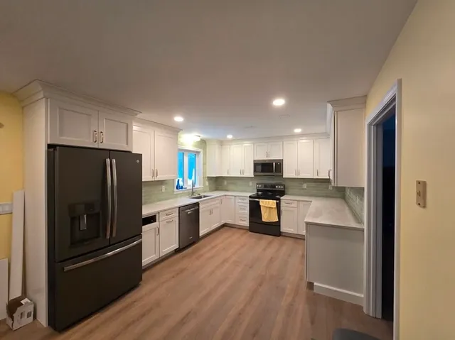 Remodeled kitchen with fresh paint, white cabinets and new flooring