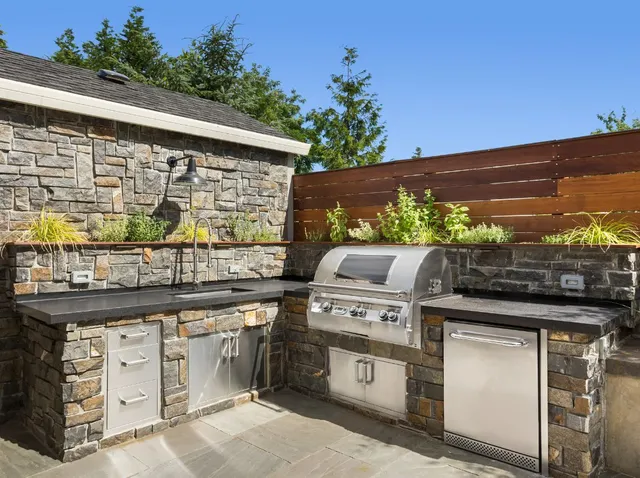 stone outdoor kitchen with stainless steel appliances