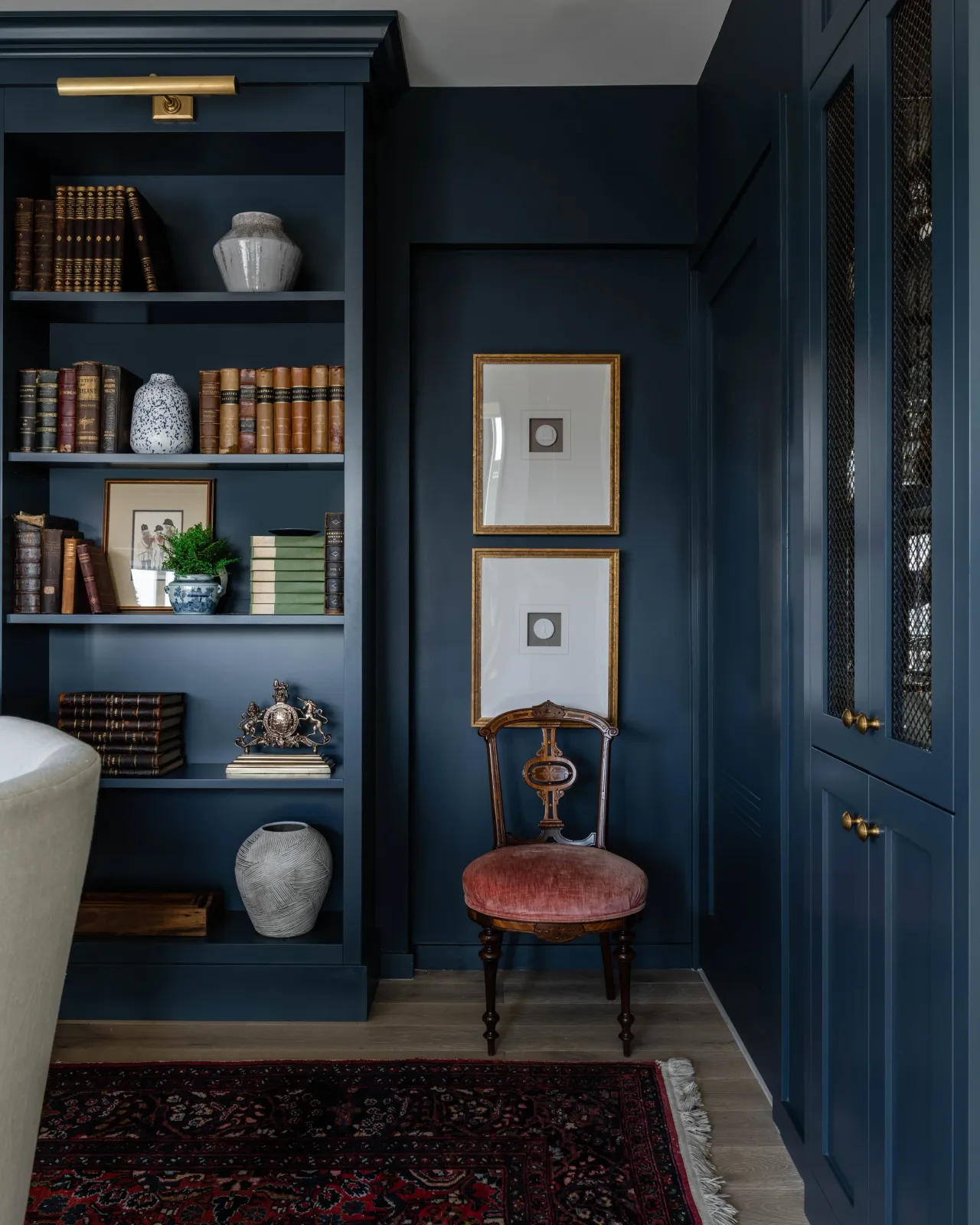Custom built in bookcase library and dining room, turning a dining room into a library, jewett farms cabientry, dark blue built ins, moody dining room, incorporating antiques, interior designer, boston condo, boston high rise condo, south end, weston