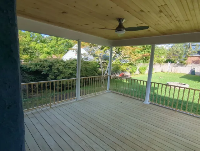 Screened porch addition with architectural columns and custom-framed invisible screening