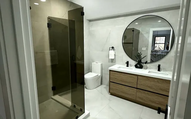 Finished bathroom remodel with walk-in glass shower and floating wood vanity