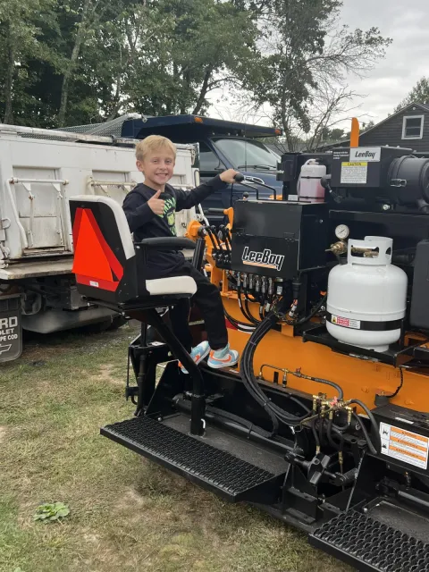 a kid riding a paving equipment