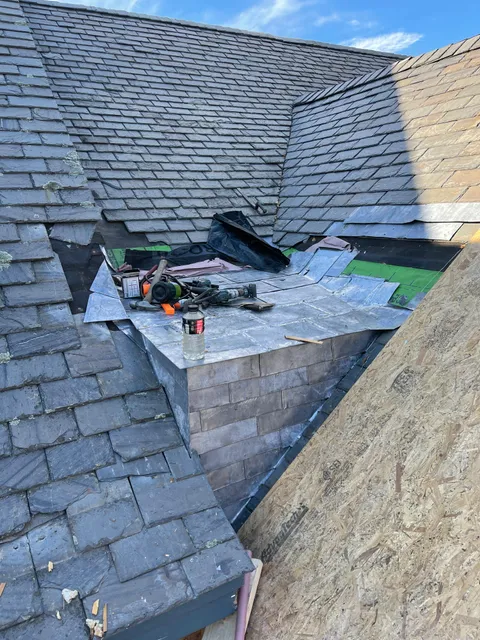 Close-up of slate tile installation with tools on site