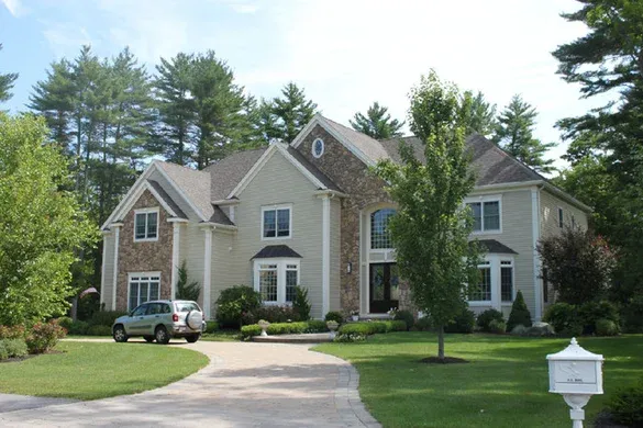 Shingle and stone custom home with columned entry