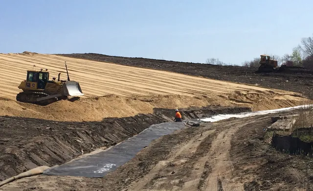 worker and bulldozer at sutton brook project site