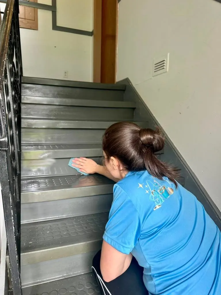 A team member cleaning the steps of a commercial stairwell