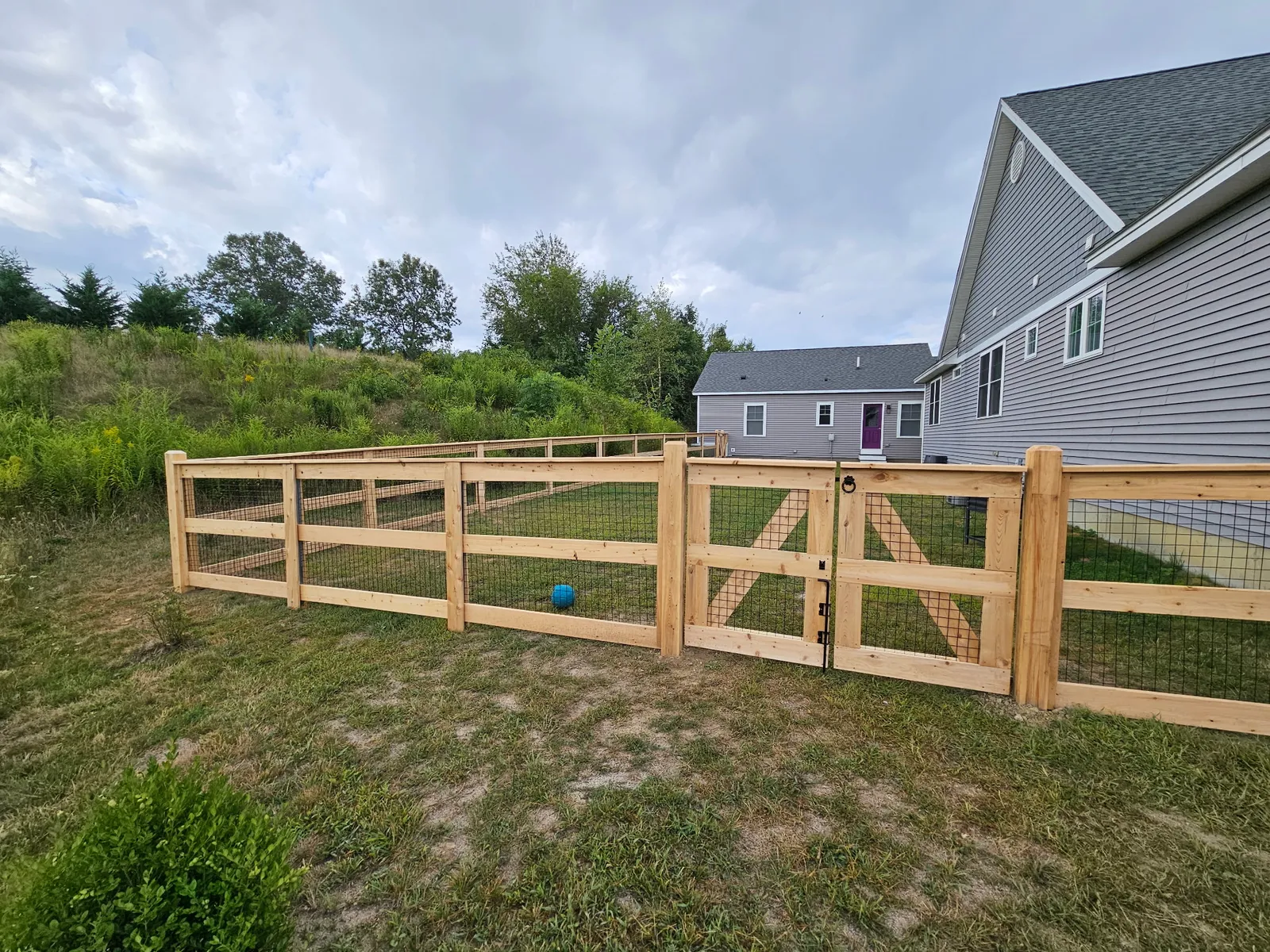 Cedar wood on wire fence installation by Olympic Fence Company in the Amesbury area featuring a no-dig system.