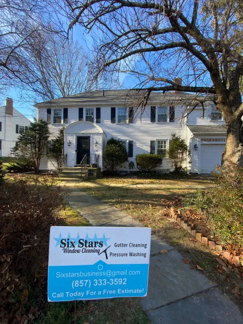A white house with a for sale sign in front of it.