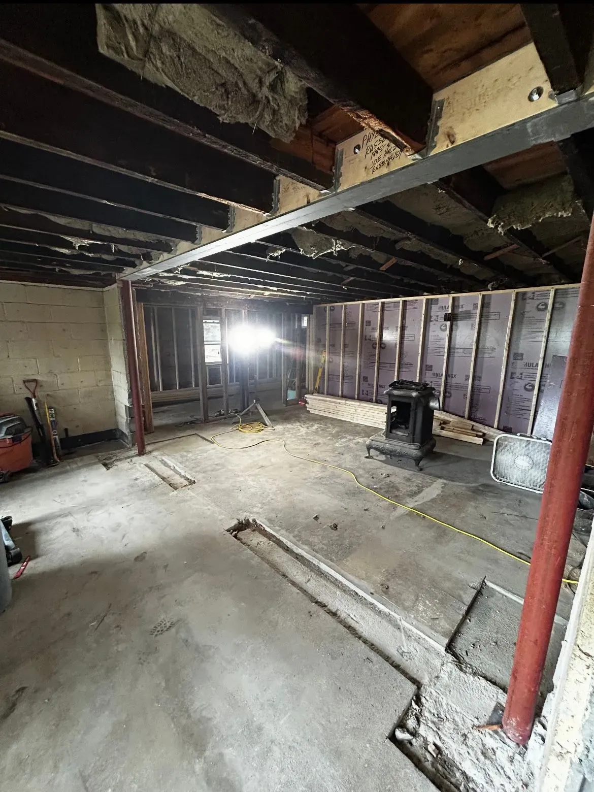 A large room with a lot of wooden beams and a concrete floor.