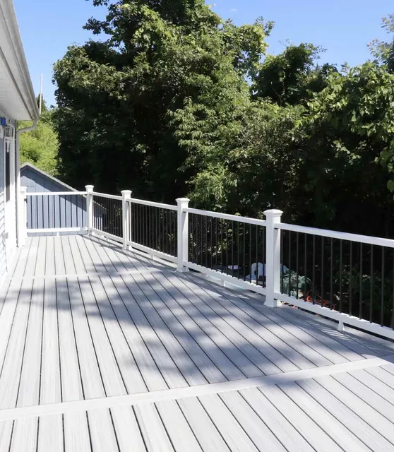 Pvc deck with black balusters railing featuring trees on the background in worcester ma