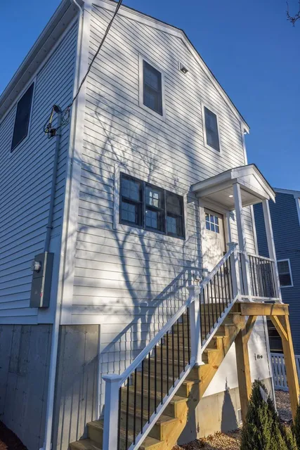 New construction custom home exterior with white siding and entry stairs by Perocchi Building & Remodeling, Plymouth MA