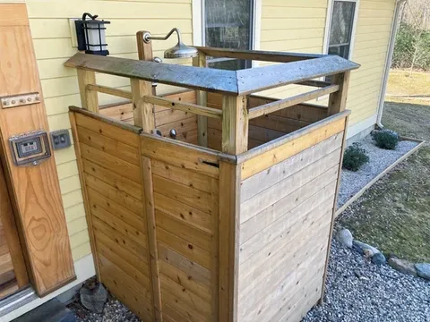 Custom cedar outdoor shower with integrated stone walkway