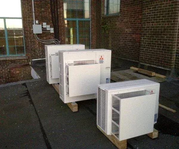 Rooftop ductless condensing units mounted on a brick building