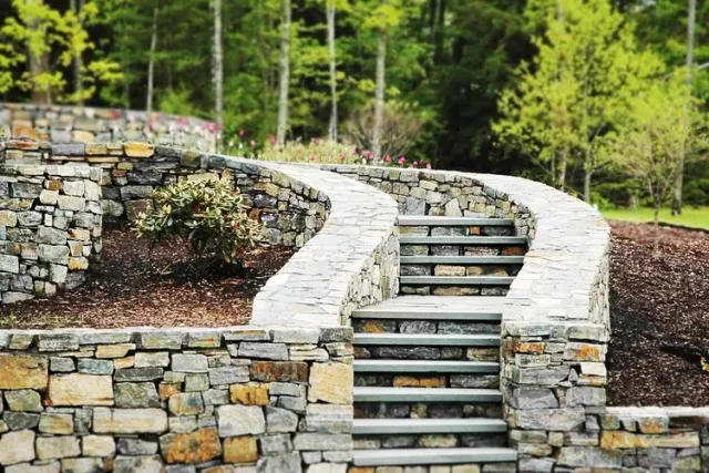Custom stone staircase and retaining wall installed by Artisan Grounds as part of a hardscaping project on the New Hampshire Seacoast.