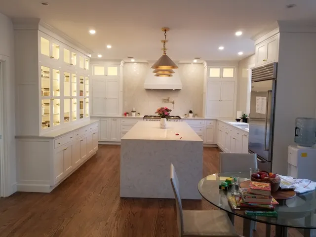Completed white kitchen with island and glass-front cabinetry