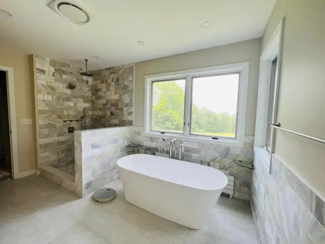 Bathroom renovation in Hanover, NH. Drywall install, tile install, trim install, cabinet install, interior painting, and new fixtures throughout!